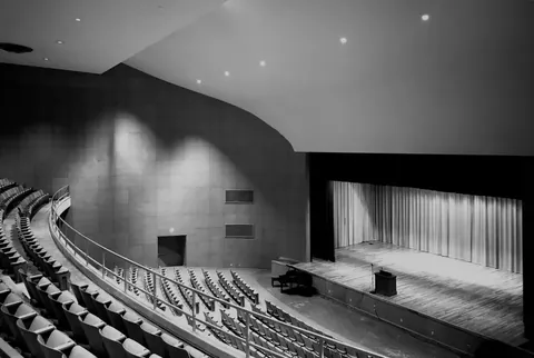 Modern auditorium with curved walls and stage ceiling