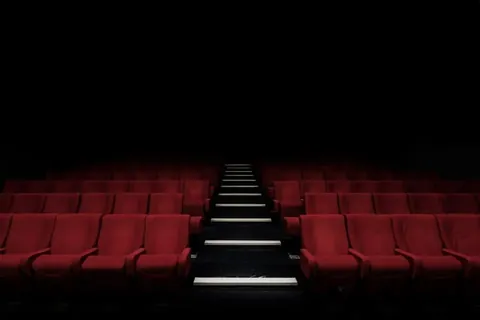 Rows of red theater seats beside a stepped aisle